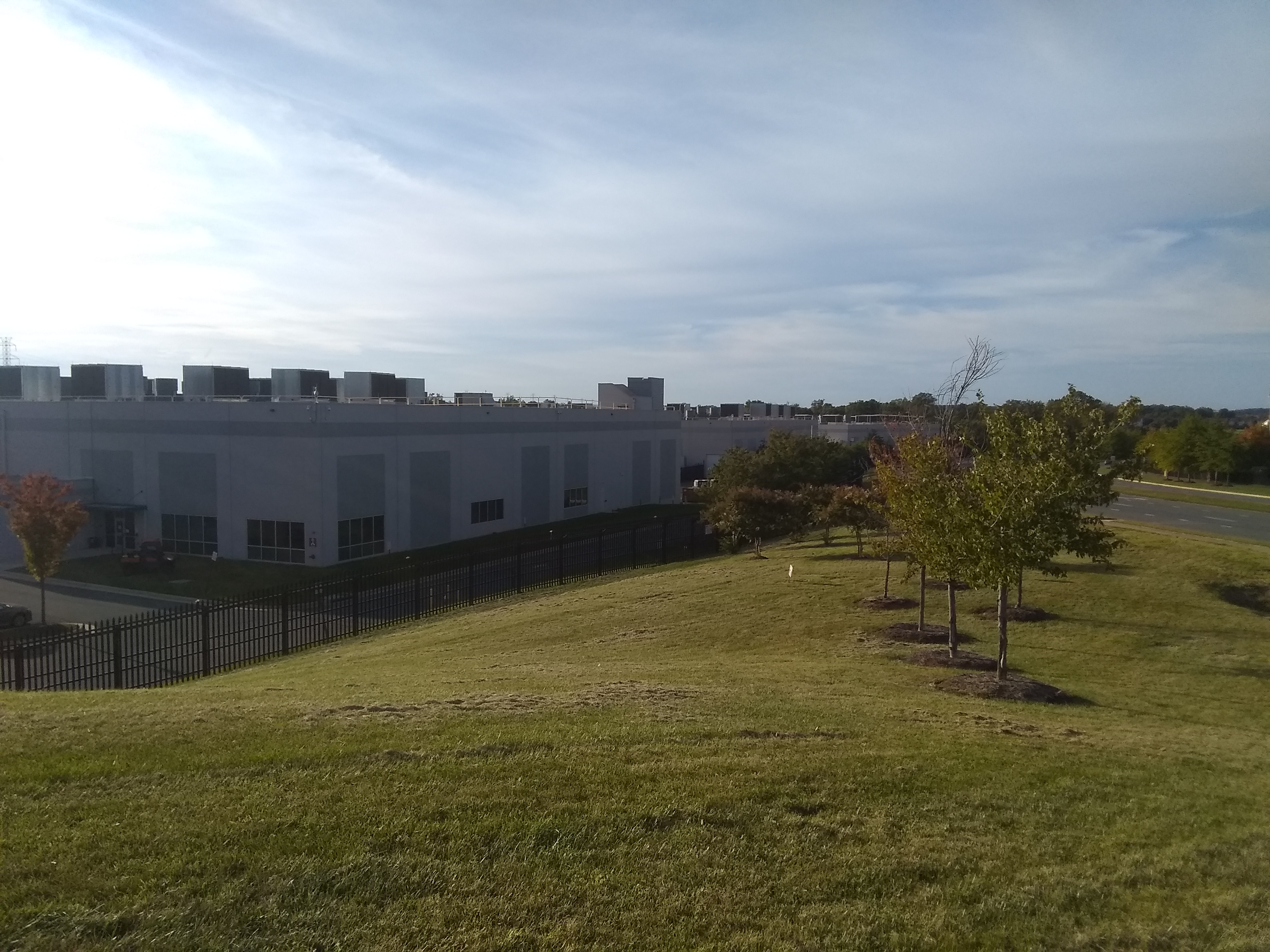 Data center building behind a grassy hill