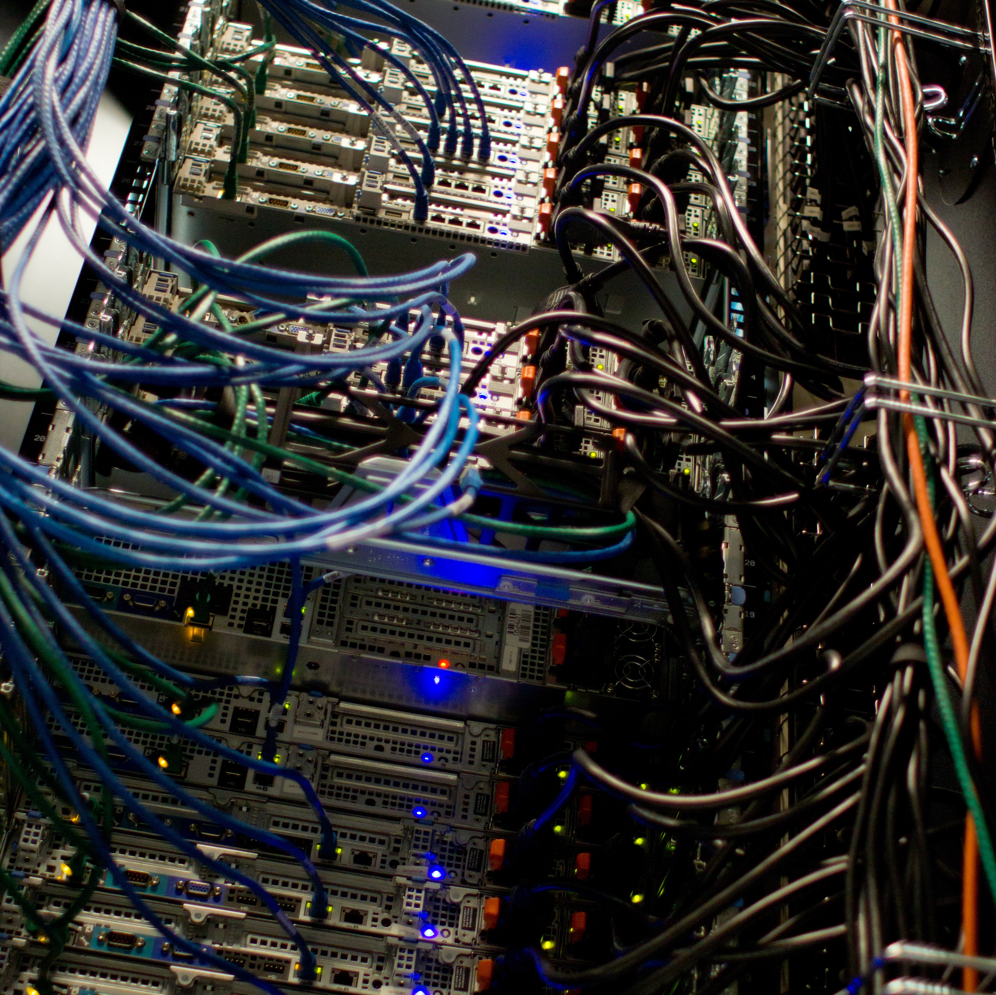 Close-up of a data center server rack packed with cables and indicator lights
